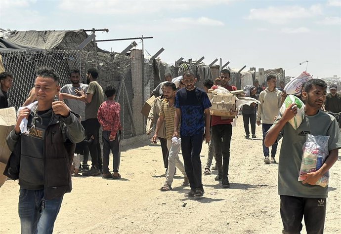 Palestinos recogen ayuda en un punto de distribución establecido por la Fundación Humanitaria para Gaza (GFH) en Rafá, en el sur de la Franja de Gaza (archivo)