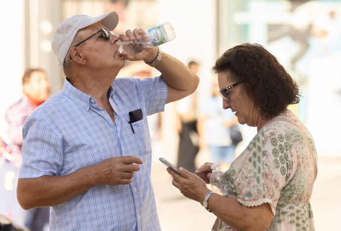 Una persona bebe agua para refrescarse ante las altas temperaturas, a 6 de octubre de 2023, en Madrid (España).