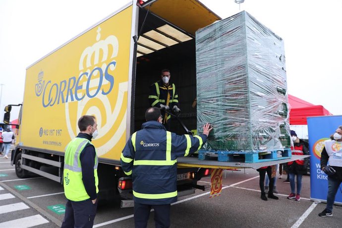 Archivo - Un camión de Correos y voluntarios llevan cajas con el fin de realizar un reparto de comida para los más vulnerables en el día de Nochebuena, en el Estadio Wanda Metropolitano, en Madrid (España), a 24 de diciembre de 2020. La iniciativa es de l