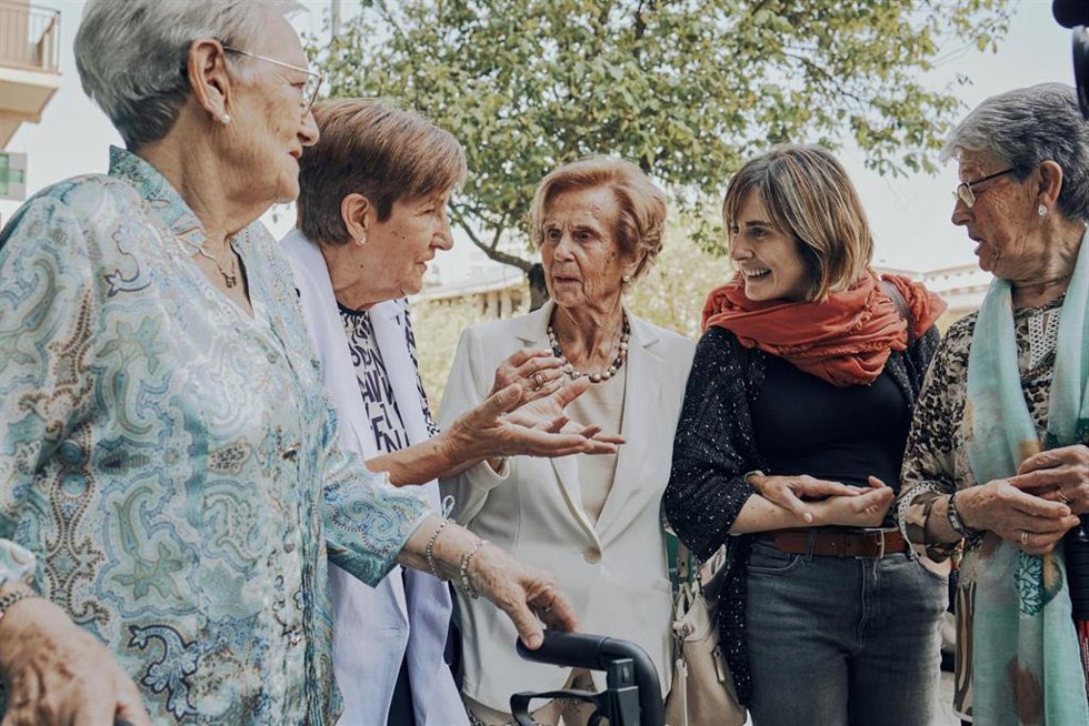 Personas mayores paseando y charlando con alguien más joven.