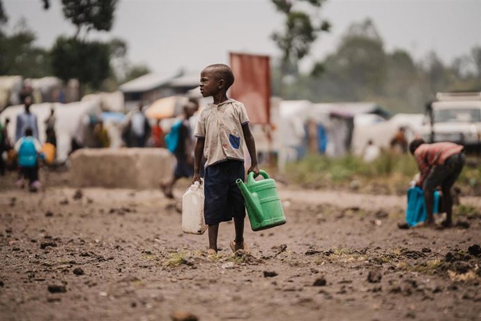 Archivo - Un niño con agua en un campo de desplazados cerca de Goma, en la provincia congoleña de Kivu Norte