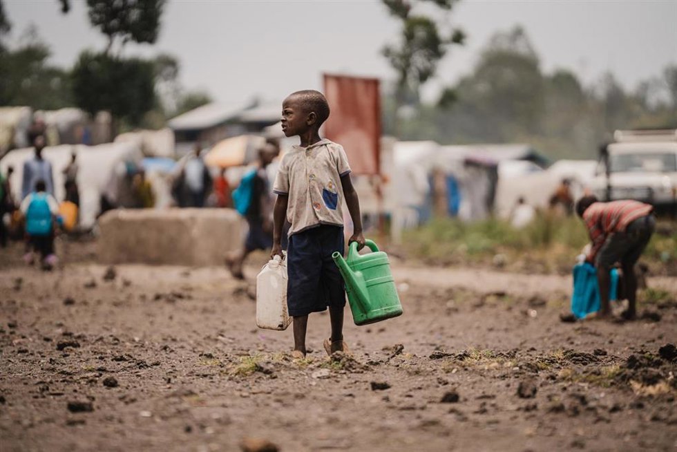 Archivo - Un niño con agua en un campo de desplazados cerca de Goma, en la provincia congoleña de Kivu Norte