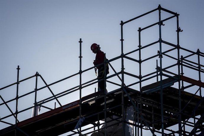 Archivo - Una persona subida a un andamio