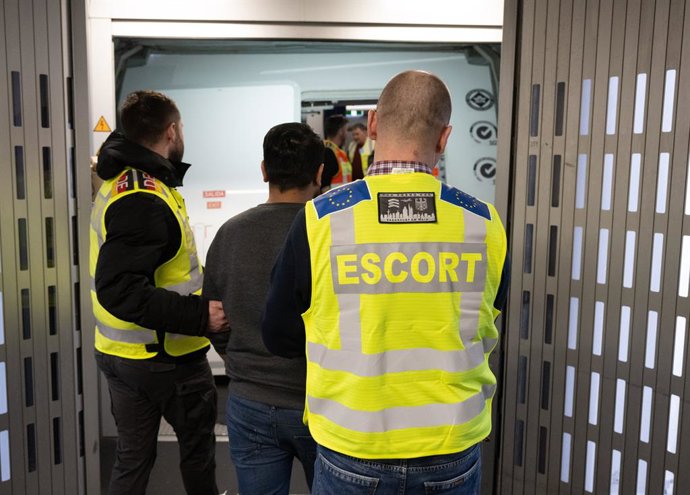 Archivo - Arquivo - 25 de fevereiro de 2025, Hesse, Frankfurt/Main: Policiais da Polícia Federal e da Frontex levam um homem em um voo de deportação para o Paquistão. A Polícia Federal e a equipe da Frontex acompanham o voo com uma mobilização maciça de f