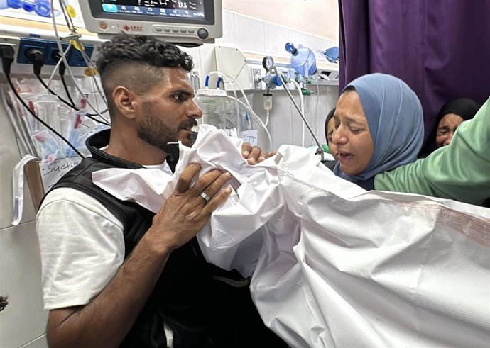 Palestinos junto al cadáver de una persona muerta por un ataque ejecutado por el Ejército de Israel contra la ciudad de Jan Yunis, en el sur de la Franja de Gaza (archivo)