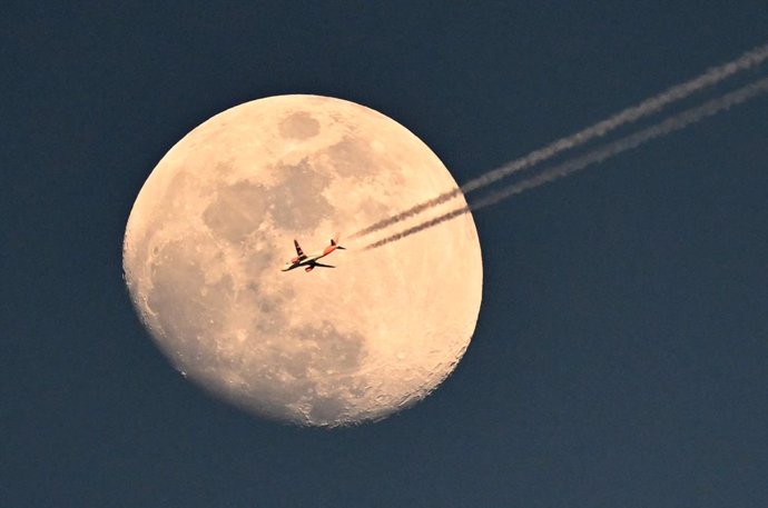 Archivo - FILED - 09 April 2025, Spain, Barcelona: An airplane flies over Olimpic Lluis Companys stadium in front of the waxing moon during the UEFA Champions League quarter-final first leg soccer match between FC Barcelona and Borussia Dortmund. Photo: F