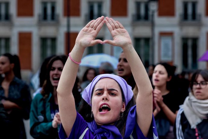 Archivo - Una mujer protesta haciendo un símbolo feminista con las manos durante una concentración en la Puerta del Sol, Madrid.