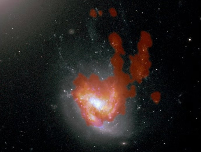 Imagem do Telescópio Espacial Hubble da NGC 4858, mostrando as gavinhas estelares que se estendem para o norte a partir do disco espiral barrado.