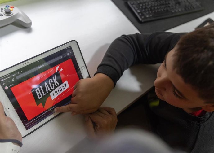 Archivo - Un joven mira una web de compras online, en Madrid (España)