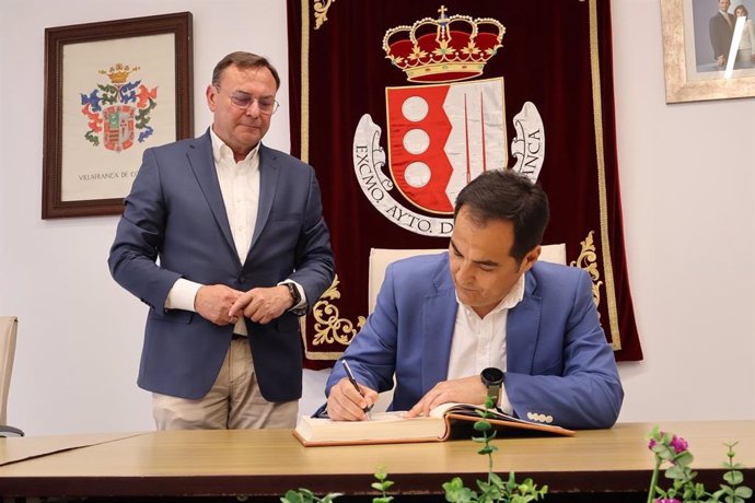 José Antonio Nieto firma en el Libro de Honor del Ayuntamiento de Villafranca, observado por su alcalde, Francisco Palomares.