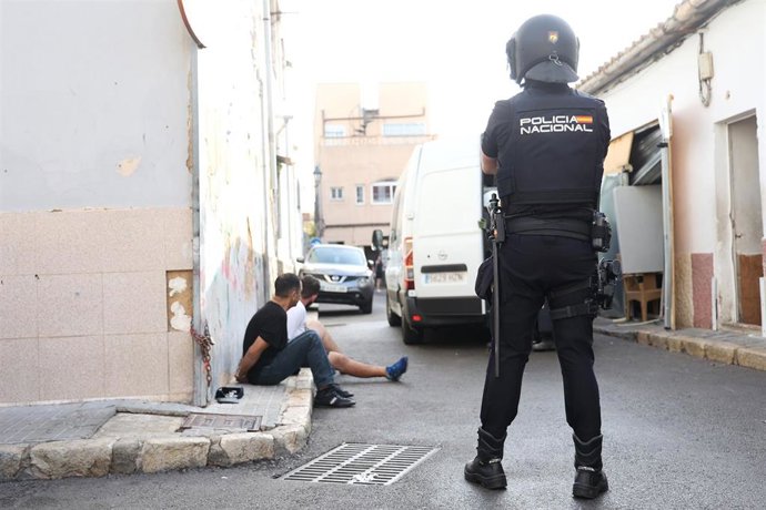 Archivo - Un agente de Policía junto a varios detenidos durante un operativo antidroga en Palma. 