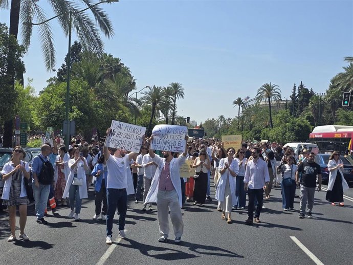 Facultativos que asisten a la huelga del Sindicato Andaluz de Médicos contra el Estatuto Marco en Sevilla, cortan la avenida de la Palmera.
