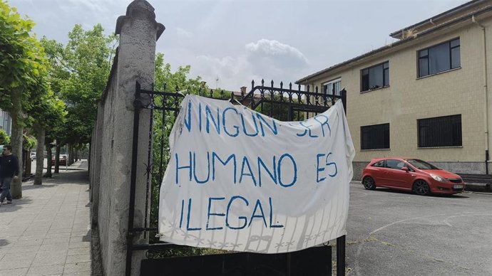 Trabajadores del Centro de Ayuda Humanitria del Colegio San José de Sotrondio colocan carteles de protesta frente al cierre inminente ordenado por el Ministerio de Inclusión, Seguridad Social y Migraciones.