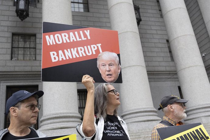 Archivo - 6 de setembro de 2024, Nova York, Nova York, EUA: Manifestantes anti-Trump do grupo Rise & Resist seguram cartazes com imagens de Trump onde se lê "MORALLY BANKRUPT" (moralmente falido) perto do tribunal enquanto Carroll (não retratado) e o ex-p
