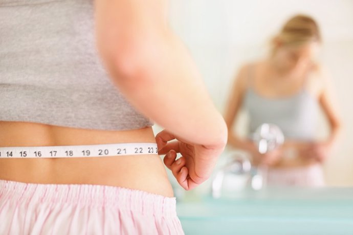 Archivo - Imagen de recurso de una mujer que mide su abdomen.