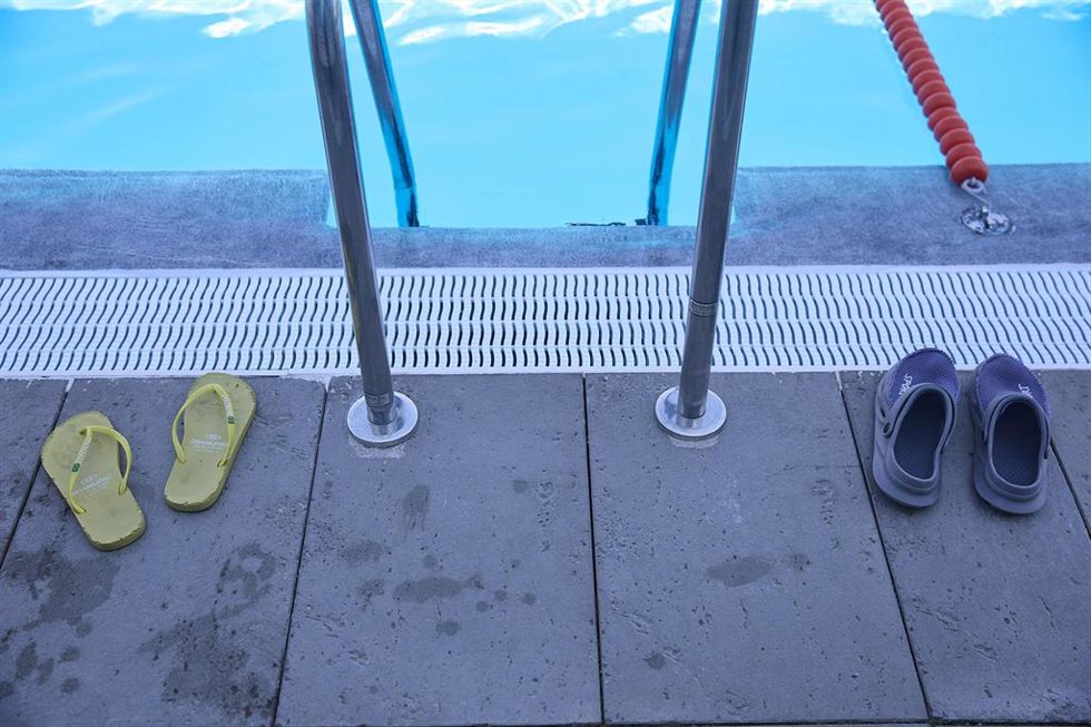 Unas chanclas y unos zuecos en la piscina del Centro Deportivo Municipal Mistral