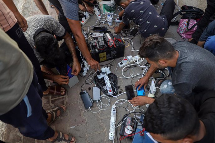 Archivo - GAZA, Oct. 27, 2023  -- People charge their mobile phones in the southern Gaza Strip city of Khan Younis, on Oct. 25, 2023. The Palestinian Islamic Resistance Movement (Hamas) launched a surprise attack on Israel on Oct. 7, firing thousands of r