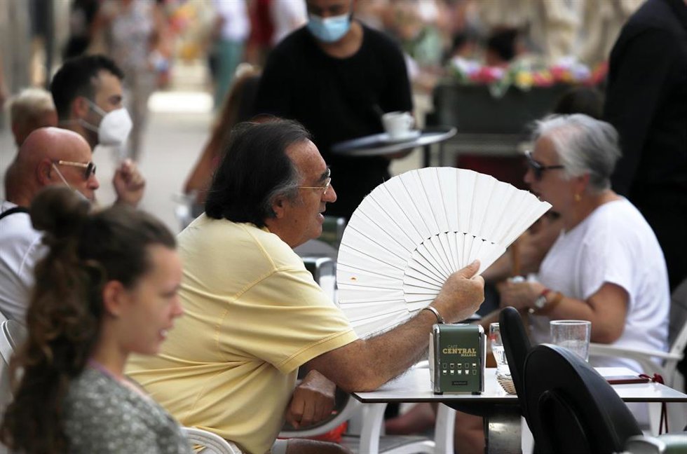 Archivo - Varias personas intentan protegerse del calor en el día, en una imagen de archivo.