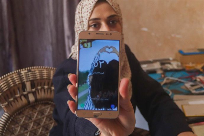 Archivo - Una joven gazatí repara móviles en su domicilio en el enclave palestino 