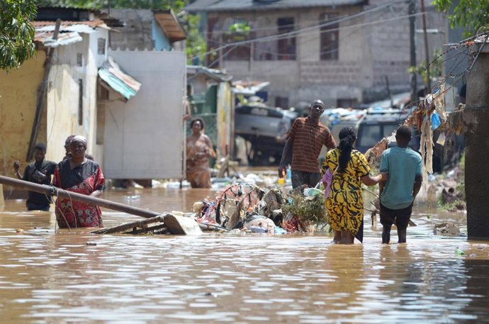 Archivo - Varias personas caminan por las calles inundadas de Kinshasa, capital de República Democrática de Congo