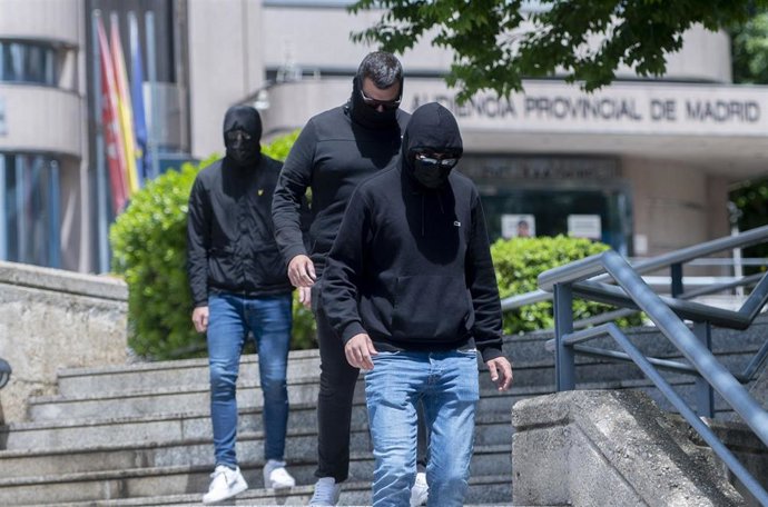Tres de los acusados del juicio contra los ultras del Frente Atlético por colgar un muñeco ahorcado de un puente, salen de la Audiencia Provincial de Madrid, tapados y de negro, a 19 de mayo de 2025, en Madrid (España). 