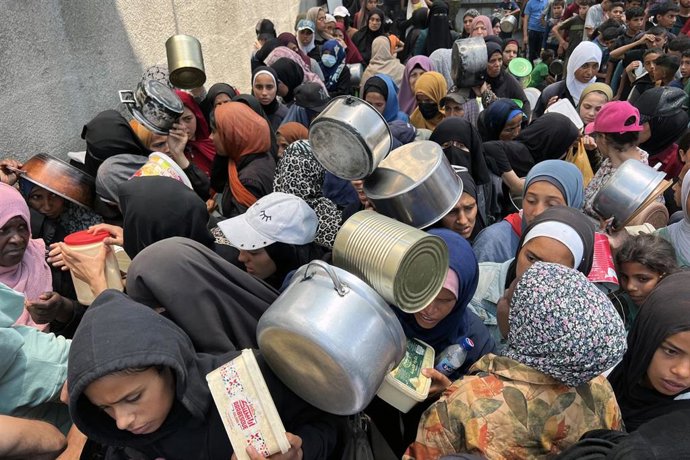 Un grupo de palestinos hace cola para recibir ayuda en la Franja de Gaza