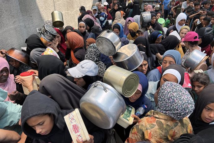 04 June 2025, Palestinian Territories, Nusairat: Displaced Palestinians gather in a charity kitchen to receive aid amid a shortage of food, in Nuseirat refugee camp. The United Nations has warned that ''the entire population of Gaza is facing the risk of 