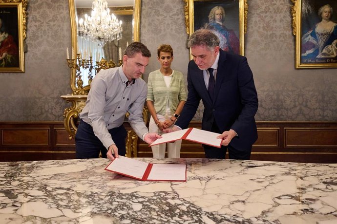 El director general de Digitalización y Recursos Educativos, Luis Calatayud, y el catedrático de Periodismo de la Universidad de Navarra, Ramón Salaverría intercambia el convenio en presencia de la presidenta Chivite