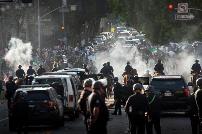 09 de junho de 2025, EUA, Los Angeles: Uma imagem disponibilizada em 11 de junho de 2025 mostra policiais da LAPD interagindo com manifestantes, durante um protesto contra batidas de imigração realizadas pelo ICE e pela polícia federal em Los Angeles. Fot