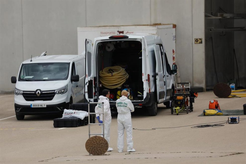 Archivo - Dos agentes de Criminalística de la Guardia Civil dentro de la parcela de la nave, junto a la fosa séptica