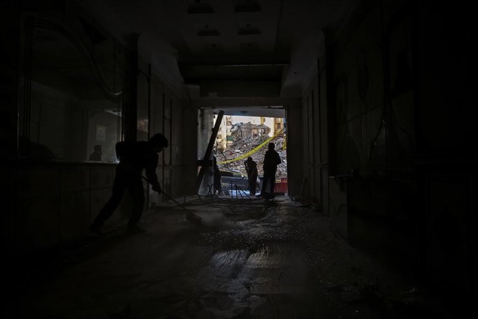 Archivo - Arquivo - 2 de dezembro de 2024, Beirute, Beirute, Líbano: Voluntários e jovens do grupo de escoteiros Imam al-Mahdi, afiliado ao Hezbollah pró-iraniano, limpam escombros e detritos sob uma ponte decorada com uma foto do líder assassinado do par