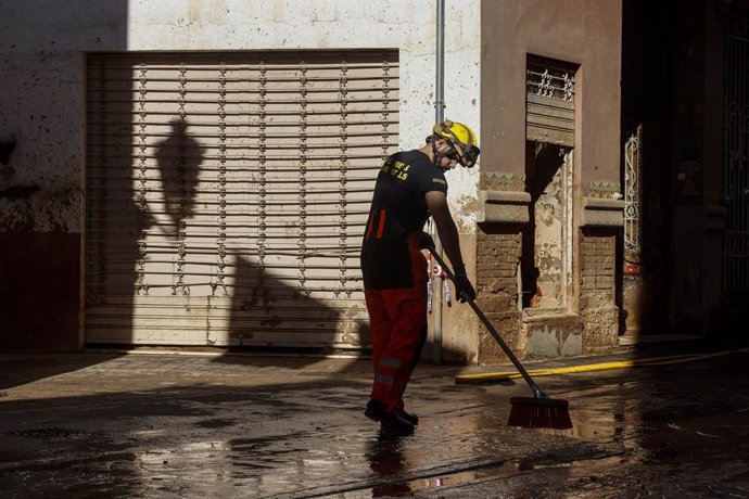 Archivo - Arxiu - Un bomber realitza labors de neteja en un carrer cobert de fang, a 28 de novembre del 2024, a Paiporta, València