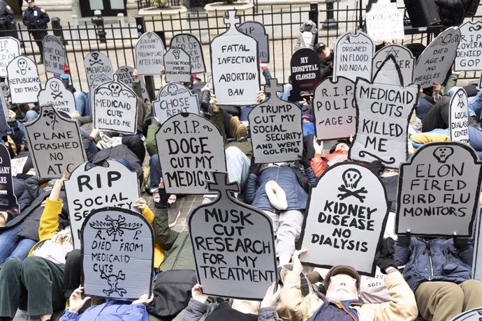 Archivo - 15 March 2025, US, New York: Demonstrators hold tombstone signs in a mass die-in outside the New York Stock Exchange NYSE. as a part of a Stop The Cuts March with thousands marching through lower Manhattan against federal budget cuts to healthca