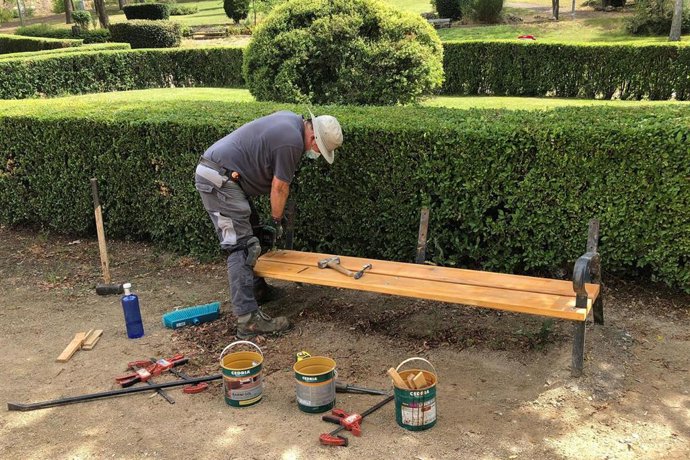 Archivo - Un trabajador de mantenimiento de parques y jardines durante la instalación de mobiliario urbano.