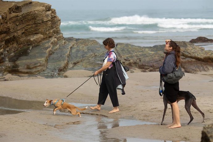 Archivo - Varias personas pasean durante la bajamar en la playa de Las Catedrales, a 19 de septiembre de 2024