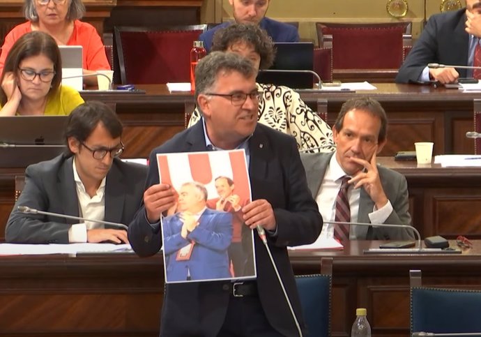 El conseller Joan Simonet muestra una foto en la que se ve a Santos Cerdán y a Marc Pons.