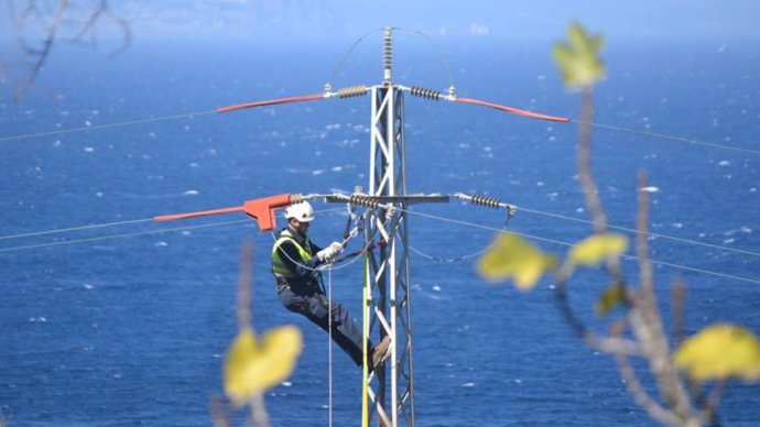Un operario trabajando en una línea eléctrica