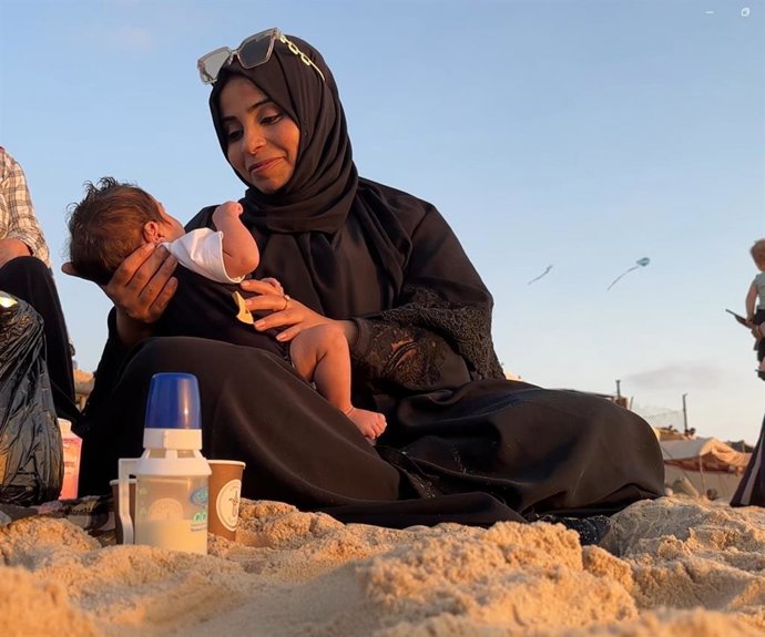 Karam en brazos de su cuidadora.