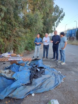 Dirigentes del PP palaciego en una de las calles del municipio con restos de basura.