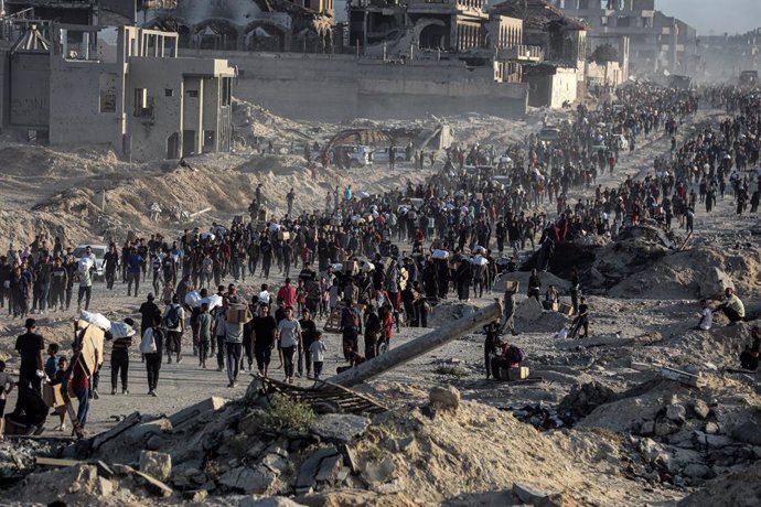 June 16, 2025, Gaza City, Gaza Strip, Palestinian Territory: Palestinians carry food parcel, distributed by 'Gaza Humanitarian Relief Foundation' as people struggle with hunger during ongoing Israeli attacks in Gaza City on June 16, 2025. Palestinians liv