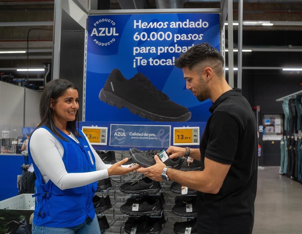 Una trabajadora de Decathlon muestra un 'Producto Azul' a un cliente