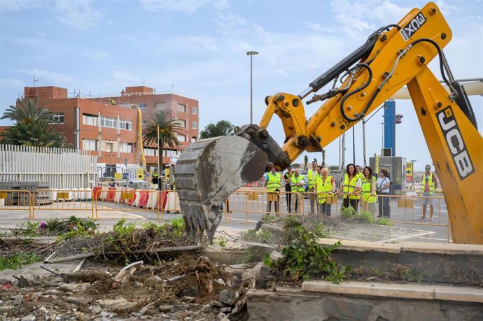Una excavadora derriba parte del vallado perimetral en el Puerto de Almería.