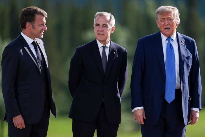 16 de junho de 2025, Kananaskis, Ab, CANADÁ: O presidente francês Emmanuel Macron, à esquerda, e o primeiro-ministro canadense Mark Carney, ao centro, ouvem enquanto o presidente dos EUA, Donald Trump, responde a perguntas de repórteres depois de posar pa