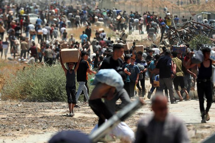 Palestinos tras una entrega de ayuda por parte de la Fundación Humanitaria para Gaza (GHF), respaldada por Israel y Estados Unidos, en la Franja de Gaza