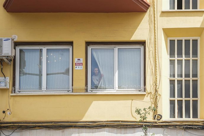 Una mujer asomada a la ventana de la casa del exministro de Transportes José Luis Ábalos durante un registro por parte de la UCO, a 10 de junio de 2025, en Valencia, Comunidad Valenciana (España). 