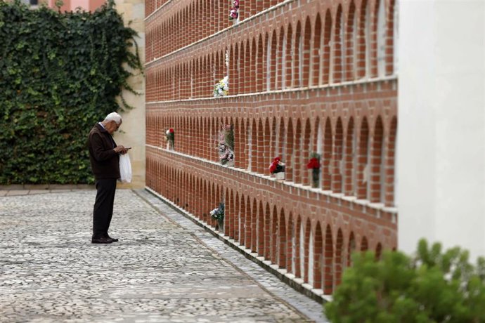 Archivo - Una persona visita y arregla un nicho en el cementerio de cementerio San Miguel en el Día de Todos los Santos