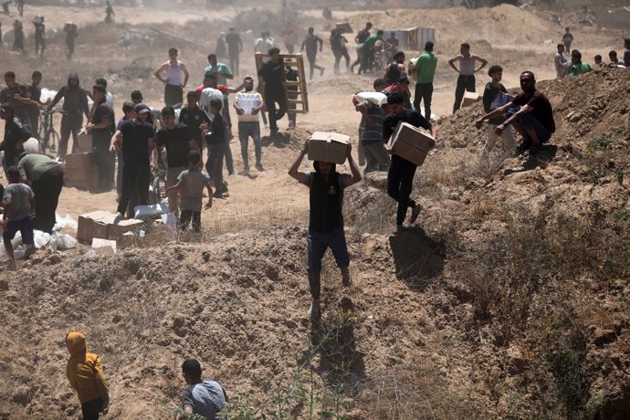 29 May 2025, Palestinian Territories, Bureij: Palestinians walk with aid supplies which they received from the US-backed Gaza Humanitarian Foundation, in Al-Bureij. Photo: Moiz Salhi/APA Images via ZUMA Press Wire/dpa