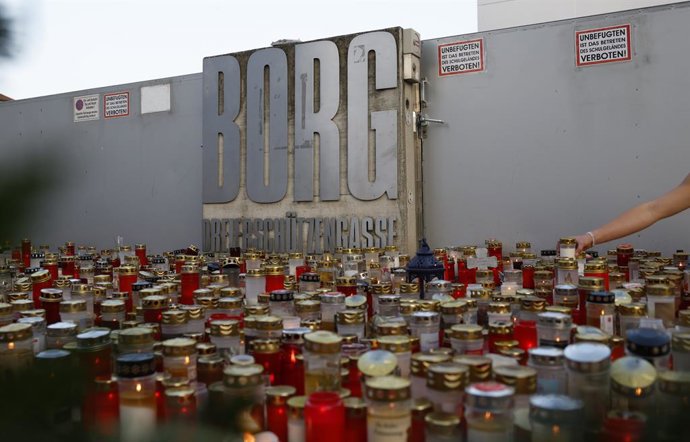12 June 2025, Austria, Graz: Candles and flowers are laid in front of the school in Graz after a rampage that left eleven dead and dozens injured, some critically. Photo: Erwin Scheriau/APA/dpa