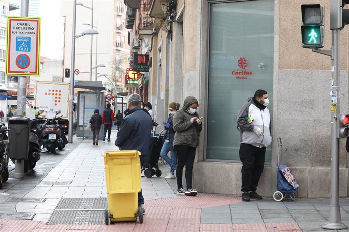 Archivo - Un fila de personas espera a entrar en el economato solidario de Cáritas situado en la calle Bravo Murillo de Madrid durante el inicio de la cuarta semana del estado de alarma decretado a consecuencia del coronavirus. 