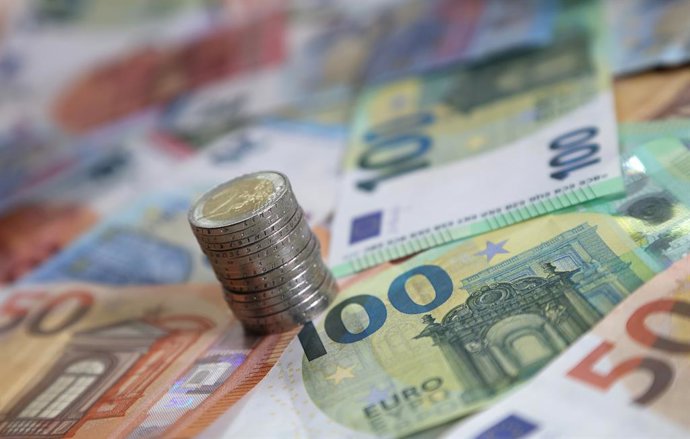 Archivo - FILED - 15 de maio de 2024, Baviera, Kaufbeuren: uma pilha de moedas de dois euros sobre várias cédulas de euro. Foto: Karl-Josef Hildenbrand/dpa